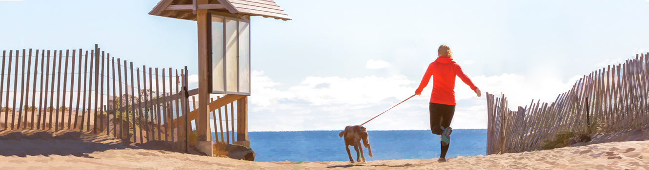 woman running with dog on beach